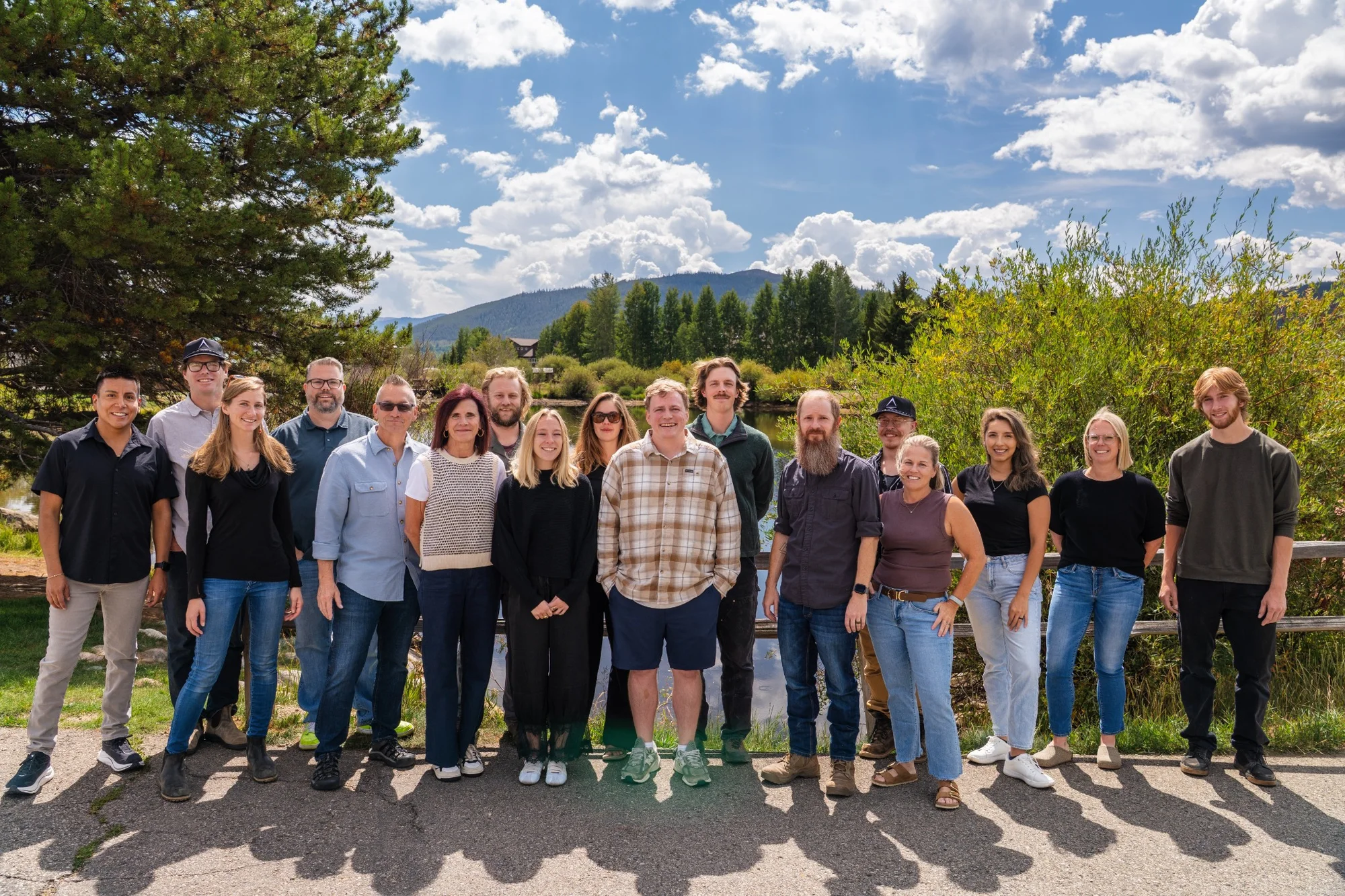 The Pinnacle Lodging team outdoors with trees and mountains behind them