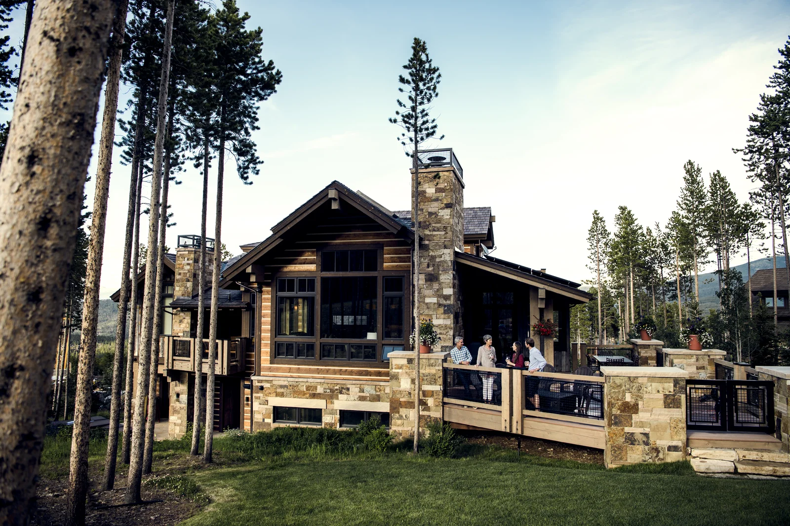 People gathering on the deck of a mountain home