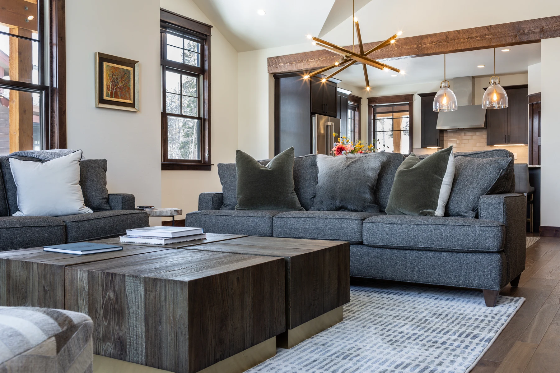 Bright mountain-home living room with comfortable sofas and an open kitchen