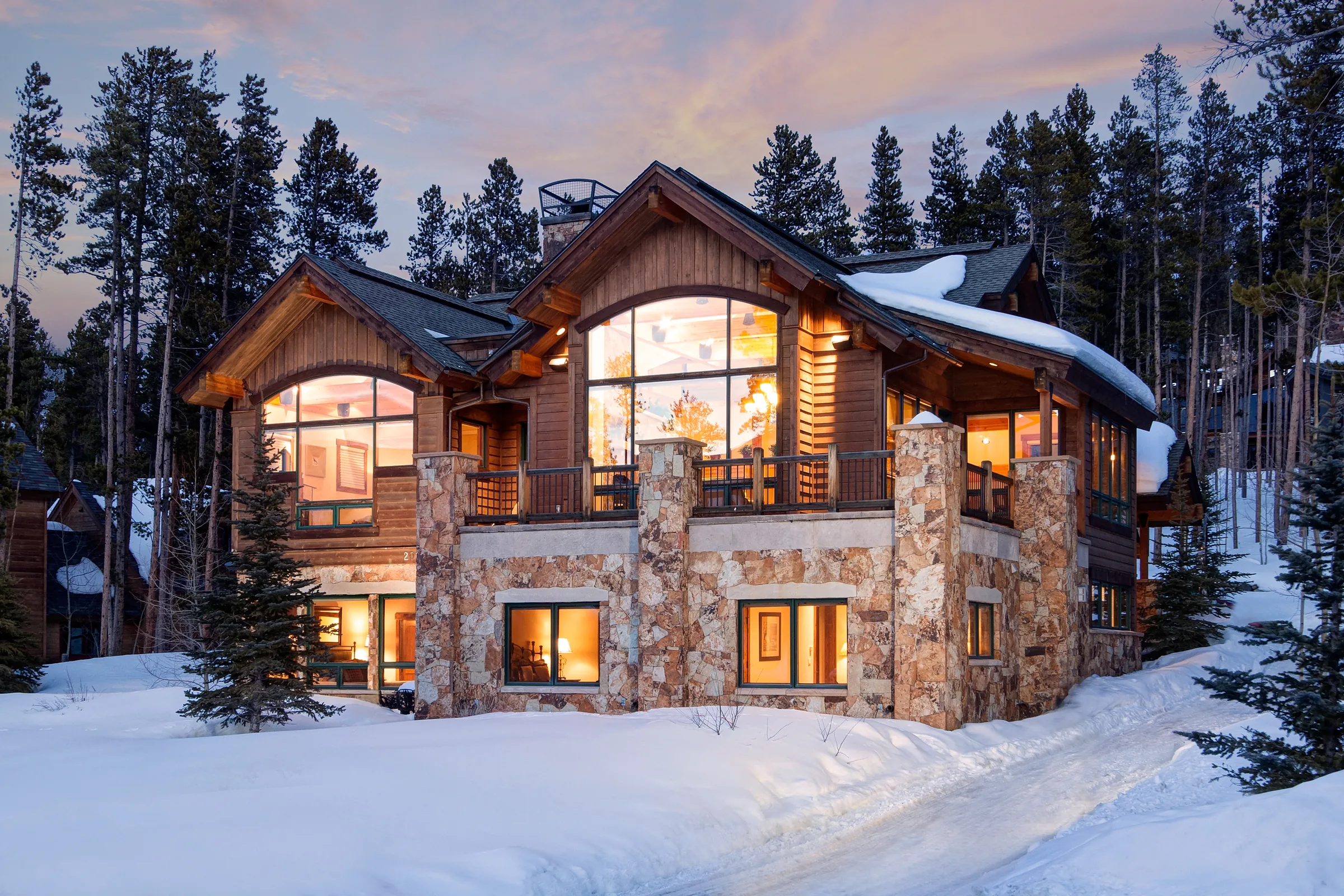 Mountain home surrounded by snow-covered evergreens