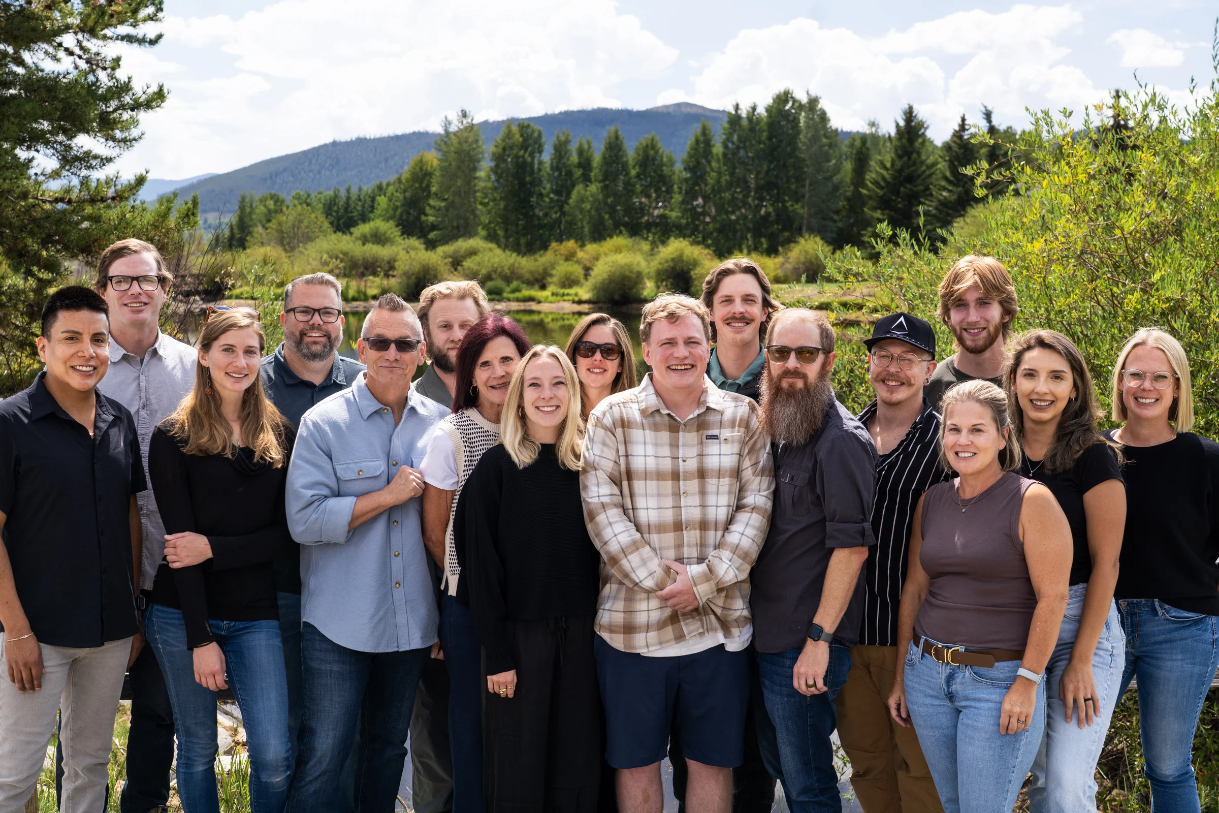 The Pinnacle team gathered outdoors in front of the Colorado mountains